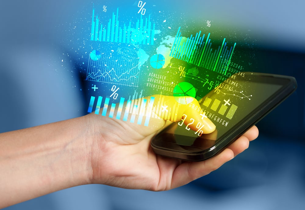 Hand holding smartphone with business diagrams on it