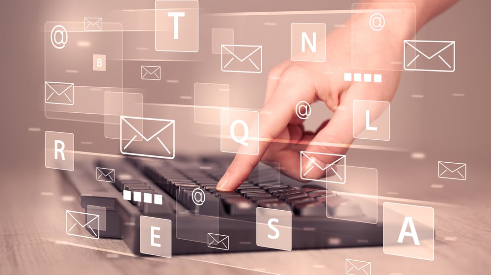 Hand typing on keyboard with digital tech icons and symbols