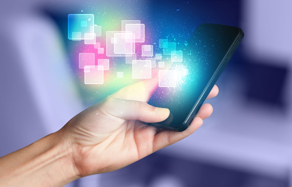 Hand holding smart phone with abstract glowing squares concept