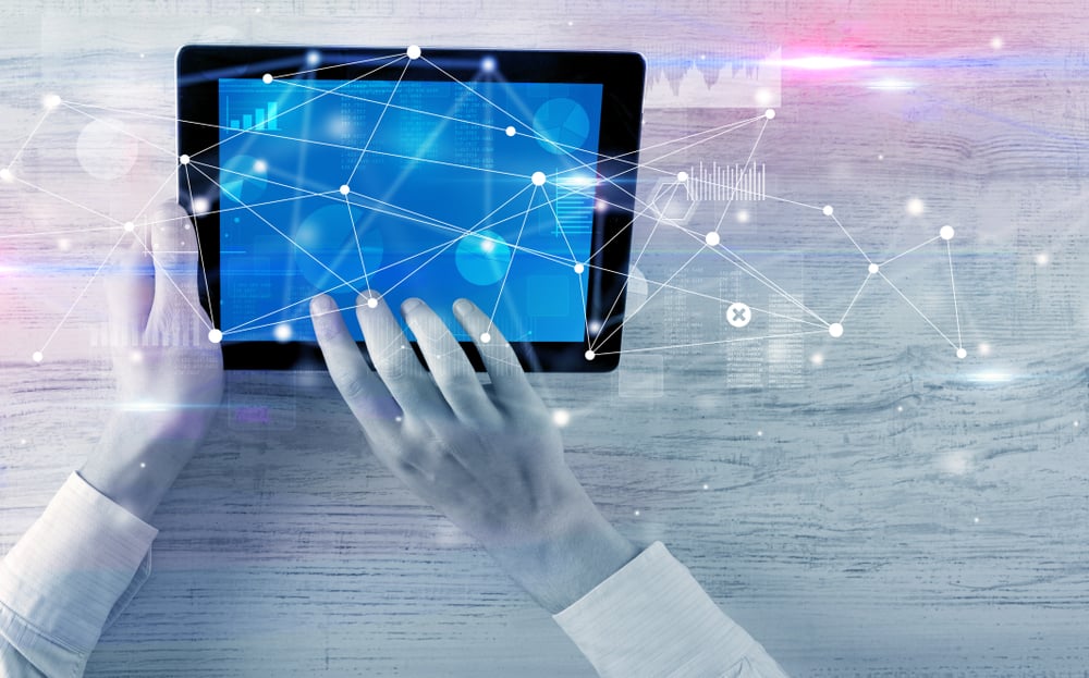 Hand using tablet with linking graphs charts  report and informational flow concept
